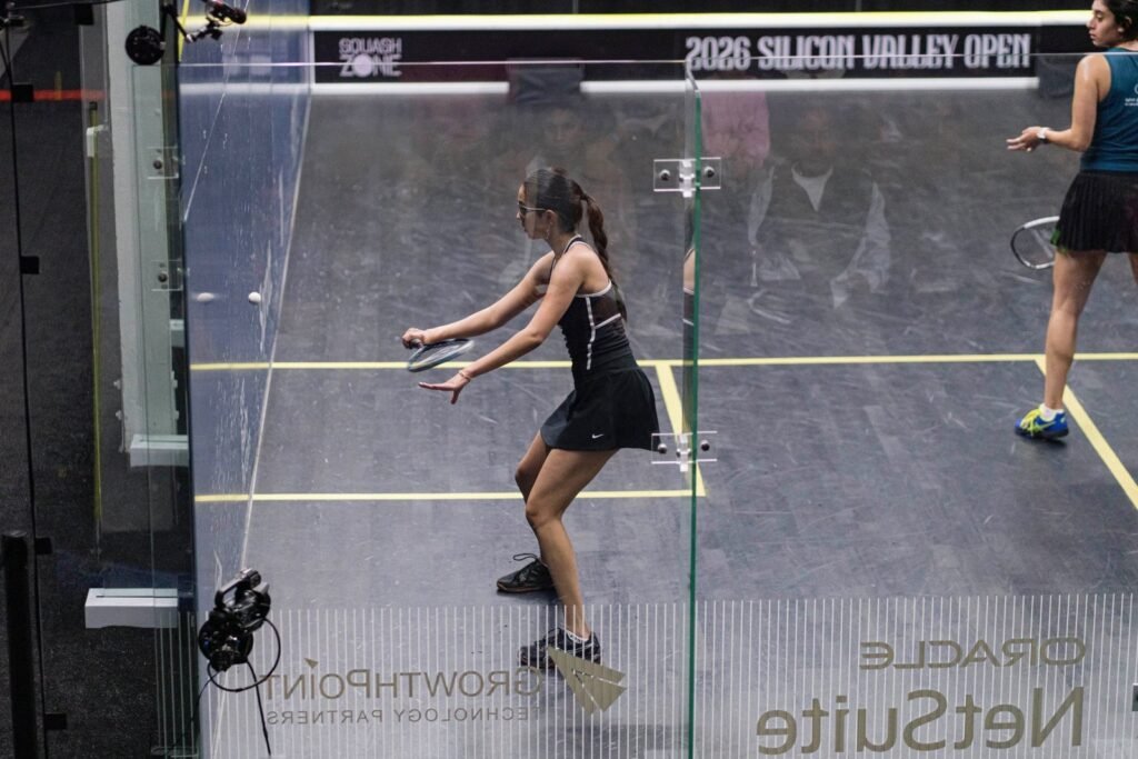 रेडवुड सिटी में 2026 सिलिकॉन वैली ओपन स्क्वैश टूर्नामेंट के ग्लास कोर्ट पर काली पोशाक में शॉट खेलती अनाहत सिंह